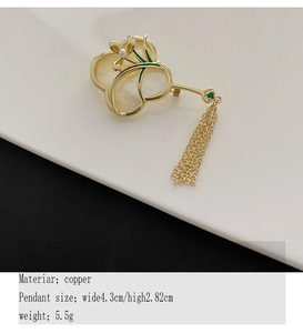 Detailaufnahme der fächerförmigen goldenen Brosche mit Quasten und Muschel-Orchideen