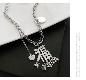 Detail einer silbernen Hip-Hop-Kette mit Fu-Schriftzeichen und Herz-Anhänger