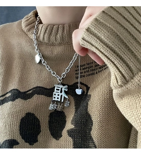 Detail der silbernen Hip-Hop-Kette mit mehreren chinesischen Fu-Anhängern auf einem Pullover