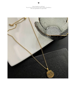 Detail of golden elephant coin pendant on fine chain with lobster clasp and extender