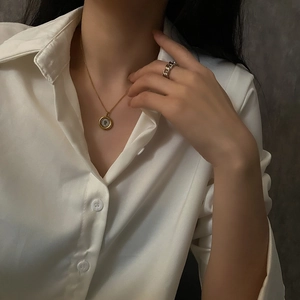 Golden elephant coin pendant necklace paired with minimalist style fashion accessories