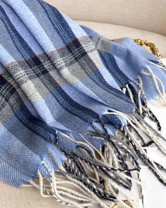 Detailed view of soft blue plaid cashmere scarf with intricate long fringed tassels