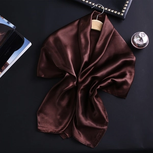 Détail d'un foulard en satin de soie marron foncé avec drapé élégant et brillant