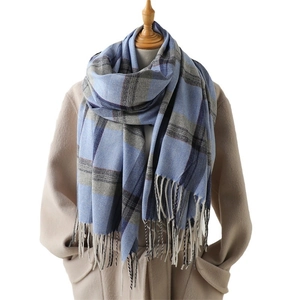 Plaid cashmere-like scarf with blue and grey checkers and tassel fringe on mannequin
