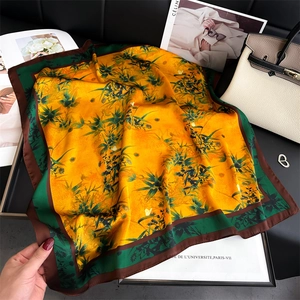 Close-up of bamboo pattern silk scarf in yellow and green with elegant silk luster