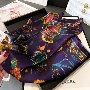 Detailed view of dark purple silk scarf with vintage floral patterns and smooth satin texture