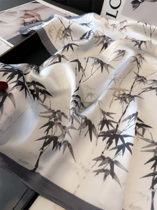 Detail of bamboo ink print on creamy white silk scarf with refined grey hemmed edges