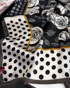Detail view of polka dot and rose silk scarf featuring yellow borders and soft textures