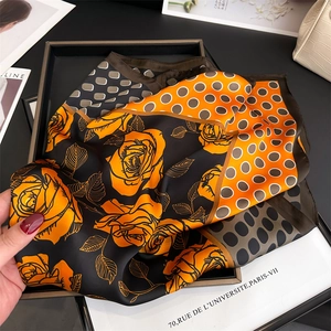 Close-up of a satin square scarf with yellow roses and polka dot pattern design