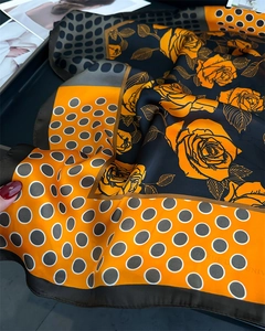 Macro detail showing vintage orange rose floral and polka dot silk satin scarf texture