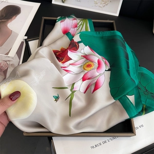Detailed view of elegant lotus print silk scarf with butterfly pattern on satin fabric