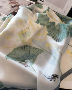 Close-up of elegant lotus and koi carp pattern on silky satin square scarf fabric