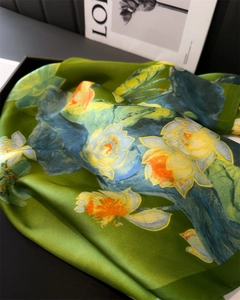 Detailed view of emerald green silk scarf with lotus pattern and elegant satin finish