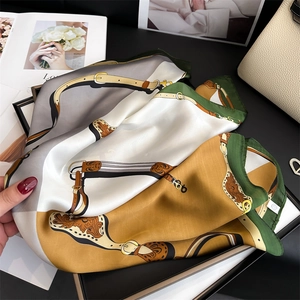 Detailed view of the equestrian pattern silk scarf with elegant horse buckle design