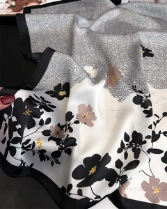 Détail rapproché d'un foulard en satin lisse avec motifs floraux et lettrage français