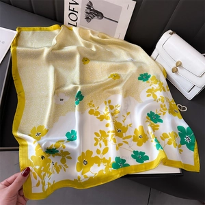 Carré de soie floral à bordure jaune, stylisé avec un sac à main blanc et un magazine