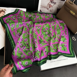 Détail d'un foulard carré en soie à motif floral géométrique vert et violet au fini soyeux