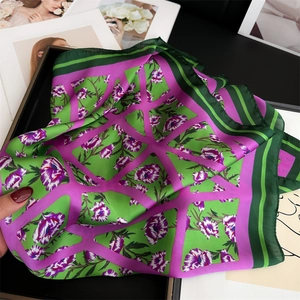 Vue détaillée d'un foulard en soie avec motifs floraux géométriques vert et fuchsia