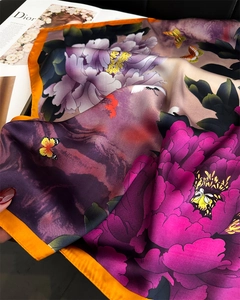 Detail of silk-like scarf with floral peony pattern and orange border on a fashion book