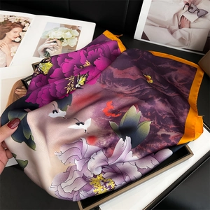 Detail of elegant silk scarf with purple peony and crane print on a magazine backdrop