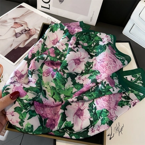 Detail of elegant floral silk scarf featuring peony prints and premium green hemmed edges