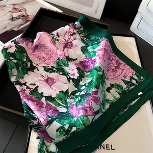 Detail of silk-like square scarf featuring elegant peony print and green border