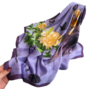 Lavender silk scarf with peony and bird print shown elegantly held by a model