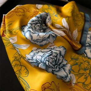 Detailaufnahme von gelbem Seidenschal mit elegantem, antikem Blumenmuster Design