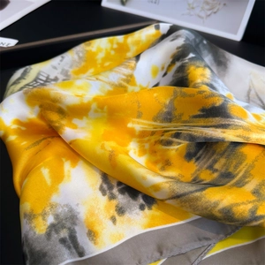 Détail d'un foulard en satin de soie avec imprimé peinture à l'huile jaune et gris