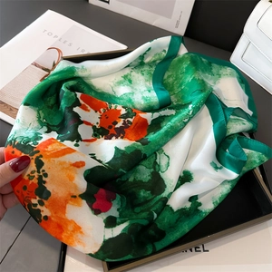 Détail d'un foulard élégant en soie avec imprimé artistique de feuilles de ginkgo et fleurs