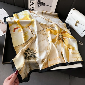 Détail d'un foulard en soie à fleurs avec motifs jaunes et bordures contrastées noires