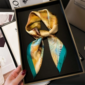 Close-up of ink landscape silk scarf with teal borders and elegant draped texture