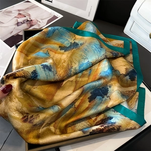 Close-up of landscape ink painting silk scarf draped elegantly over a white leather bag
