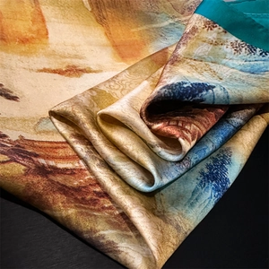 Detailed macro view showing the silky texture and artistic ink painting on the scarf