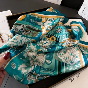 Close-up of turquoise landscape silk scarf in black gift box showing soft fabric texture
