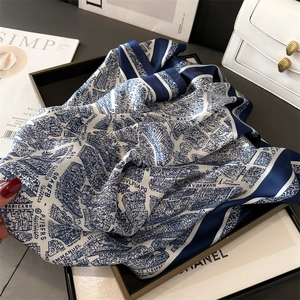 Close-up of blue and white city map printed silk scarf tied on a luxury leather handbag