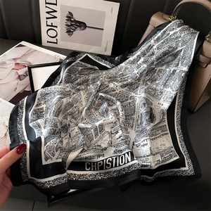Elegant black and white map print silk scarf styled over a luxury leather handbag