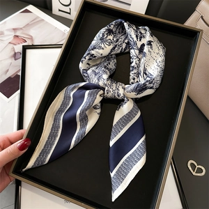 Navy blue and white floral Toile de Jouy silk scarf on a luxury display tray