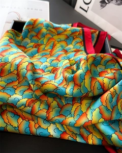 Vue macro détaillée de motifs de nuages colorés sur une écharpe en satin de soie en coffret
