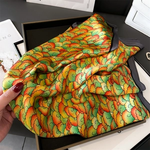 Détail d'un foulard en soie aux motifs de nuages colorés dans un coffret noir