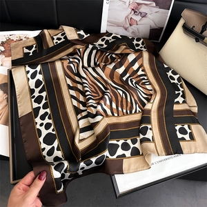 Detail of satin scarf featuring leopard and zebra print patterns with gold chain design