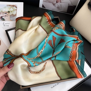 Dettaglio di un foulard in seta da 70cm con motivi a catena e nappine retrò