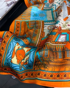 Detail of silk scarf showing vintage carriage pattern and geometric borders in vibrant orange