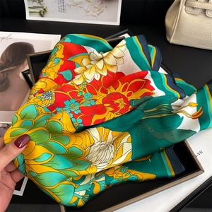 Detailed view of peony floral print silk scarf showing smooth satin texture and vivid colors