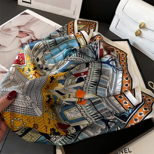 Close-up of printed silk scarf with geometric architectural patterns and glossy texture
