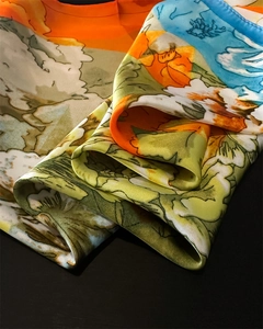 Detail of silk scarf with floral prints and satin texture against a black background