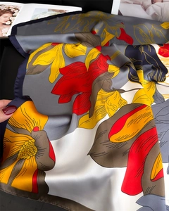 Detail of silk-like floral square scarf showing smooth satin texture and floral print
