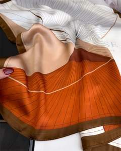 Detail of silk-like square scarf featuring abstract geometric orange and brown lines