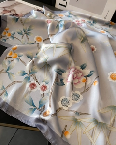 Dettaglio dell'elegante foulard in seta con motivi di peonie e trama in raso