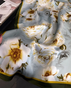 Dettaglio ravvicinato di foulard in seta con rose stampate e motivi botanici vintage